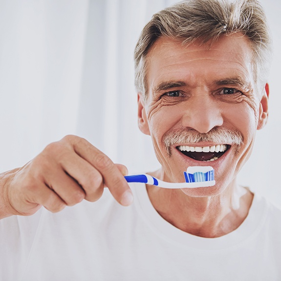 Man in white shirt about to brush his teeth